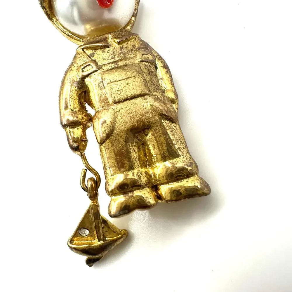 Vintage gold tone boy child with sailboat faux pearl articulated figural brooch